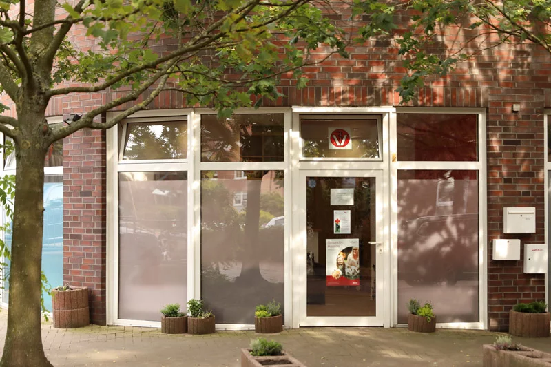 Modern gestaltete Außenansicht der Tierarztpraxis Wettbergen mit Backsteinfassade, großflächigen Fensterfronten und einladendem Eingangsbereich.